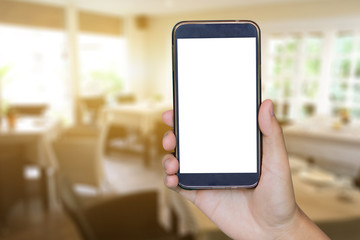 Man hand holding mobile smart phone , tablet,cellphone over Blur or Defocus image of Coffee Shop or Cafeteria,Customer at restaurant blur background with bokeh ,vintage color,food online call shopping