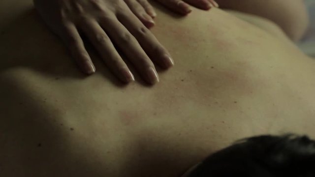 Female's hand touching man's back. Part view of a woman's hands caressing a man's bare back.