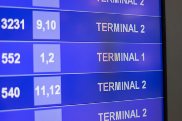 Arrival Departure Board showing departing flights ,LED info of flight on billboard in airport,show text message of Terminal 1,2,selective focus