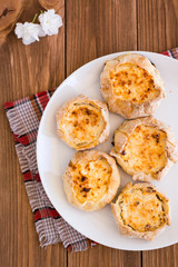Аппетитные ватрушки с творогом на тарелке на деревянном столе