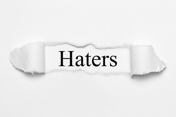 Haters on white torn paper