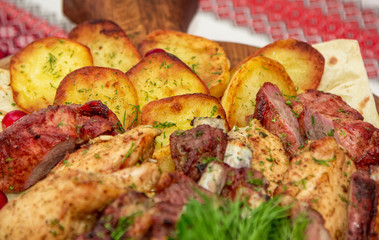 Closeup assorted barbeque plate. Grilled potato and meat platter- beef, pork ribs, chicken fillet and dill.