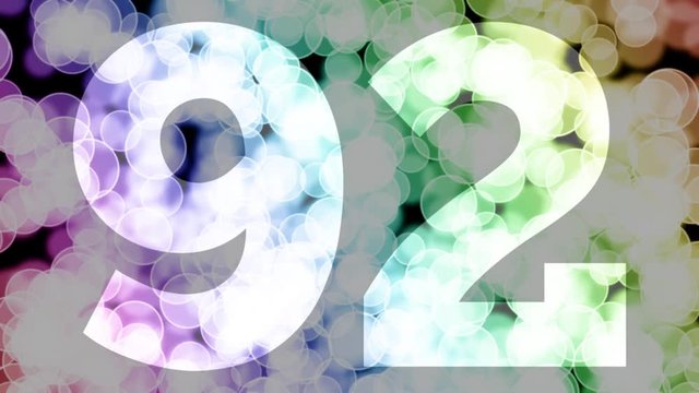 Ninety two to ninety three years birthday fade in/out animation with color gradient moving bokeh background. Animation: 90 frames still with number, 180 fade out, 30 clear, 180 fade in, 300 still.