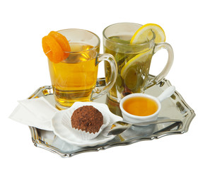 Two cups of green tea with mint,  cinnamon,  lemon,  dried apricots.  Served with honey and cake.  Isolated on a white background. Ready for menu