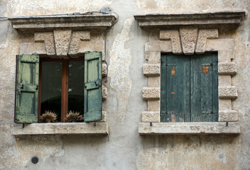 Old window shutters in ancient stone wall. Verona, Italy