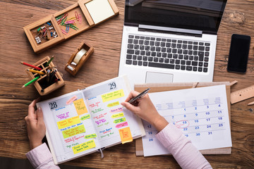 Businesswoman Writing Schedule In Calendar Diary