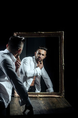 muscular macho man with sexy athlete body near vintage mirror