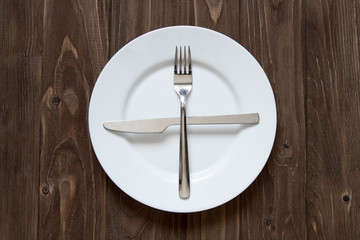 Plate and cutlery on wooden background in ready for next form