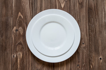 Two white ceramic plate on wooden background