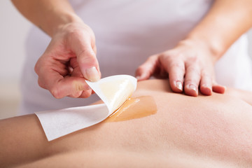 Woman Waxing Man's Chest With Wax Strip