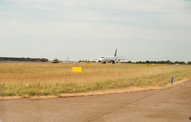 Fototapeta na wymiar Airplane taxiing on the runway, preparing departure - take off after landing