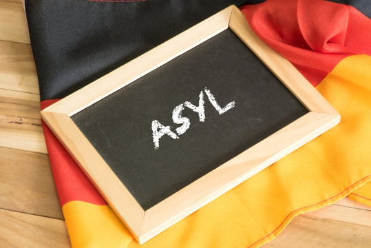 Deutsche Flagge und eine Tafel mit dem Wort Asyl