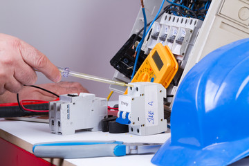 electrician fixing  electrical devices with different tools