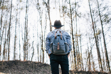 Traveler bearded man standing and enjoying a beautiful nature in the spring forest