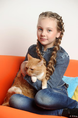 Girl with a red cat at home
