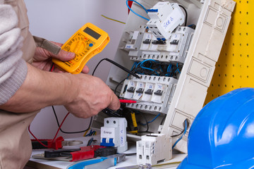 electrician fixing  electrical devices with different tools