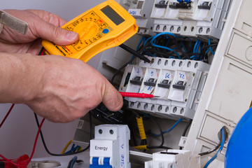 electrician fixing  electrical devices with different tools