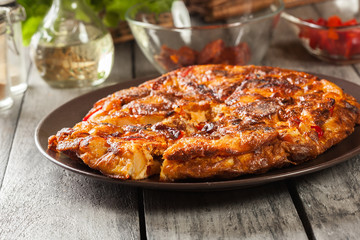 Tortilla de patatas. Spanish omelette with sausage chorizo, potatoes, paprika and egg, accompanied by olive oil