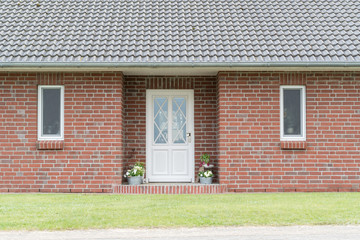 Eingangsbereich eines Hauses mit Haustür und Fenstern