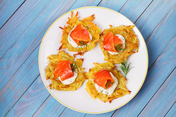 Potato Pancakes With Salmon. Vegetable fritters with fish. Latkes on a plate. View from above, top studio shot