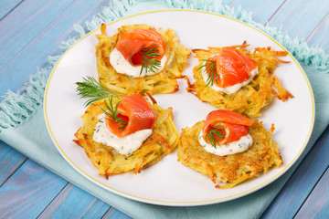 Potato Pancakes With Salmon. Vegetable fritters with fish. Latkes on a plate