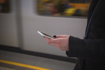 Female using smartphone at the train station 