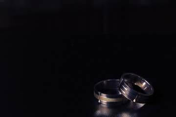 Pair of golden wedding rings on black background 
