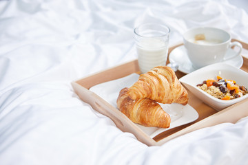 breakfast in bed with coffee and croissants