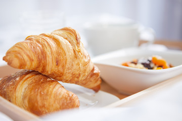 breakfast in bed with coffee and croissants