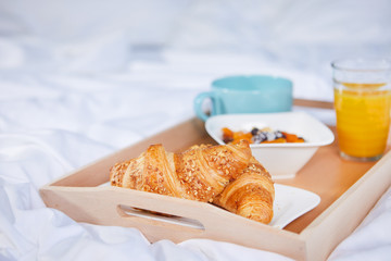 breakfast in bed with coffee and croissants