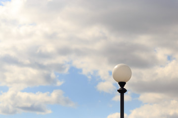 Lonely lamppost against the sky and clouds