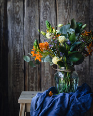 Spring flowers on a wooden chair with blue cloth on a wooden background © Марина Кузнецова