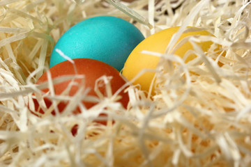 Easter eggs in nest on wooden background, close-up.Selective focus