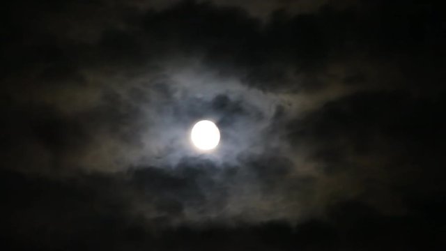 Time lapse of Spooky moon behind clouds at night 