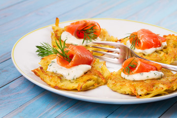 Potato Pancakes With Salmon. Vegetable fritters with fish. Latkes on a plate