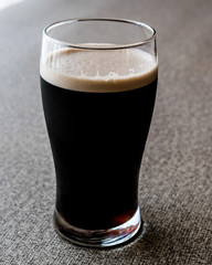 Dark Beer on grey surface. copy space.