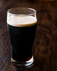 Dark Beer on wooden surface. Close up view.