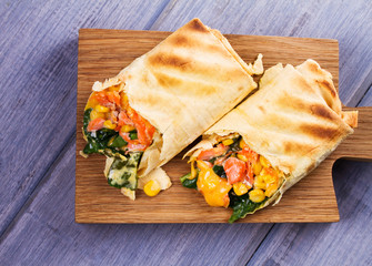 Salmon, Spinach, Cheddar and Corn Burritos. Fish Wraps. View from above, top studio shot