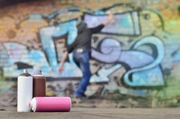 A photography of a certain number of paint cans against the graffiti background