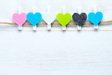 Colorful hearts on a twine on old wooden background.