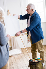 Fototapeta premium senior man getting ready to draw woman portrait in workshop