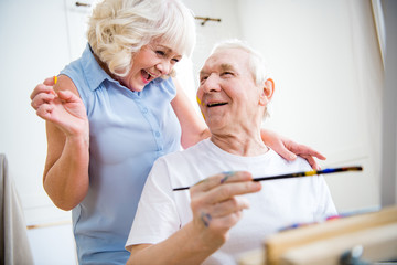 portrait of happy senior man and woman in art workshop