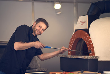 Chef einer Pizzeria mit Steinofen
