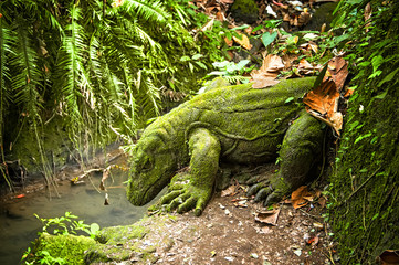 dragon stone sculpture covered with moss in a rainforest