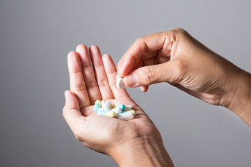 Medicine pills and capsules in woman hands