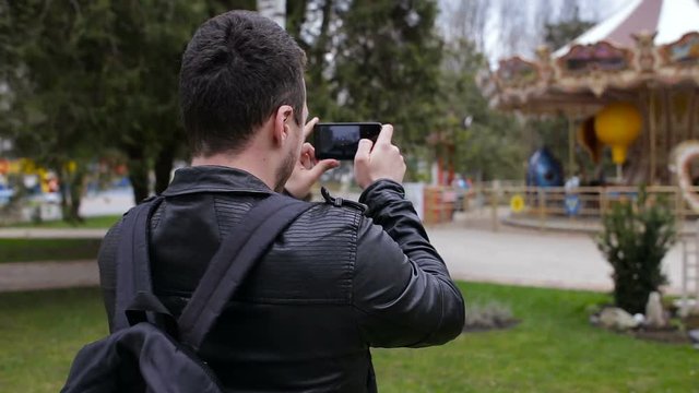 Happy man doing selfies on smartphone in the park