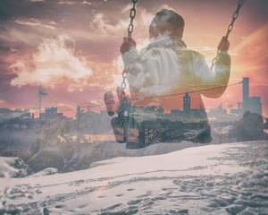 Multiple exposure of kid on swing and city skyline with snowy mountainscape