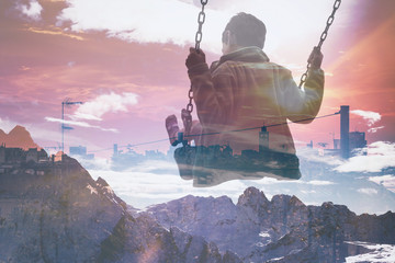 Multiple exposure of kid on swing and city skyline with mountainscape