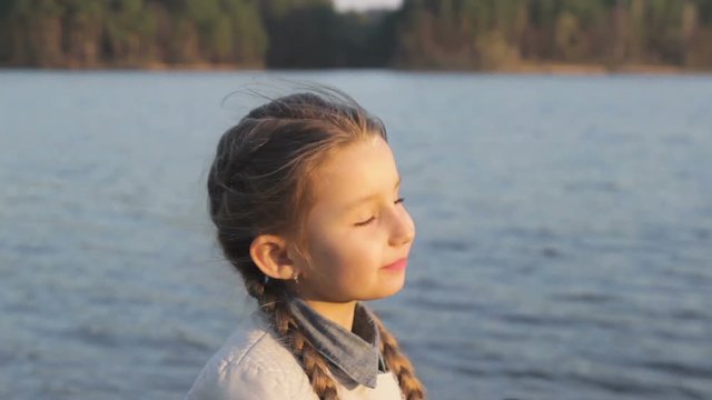 little smiling girl takes photos of nature