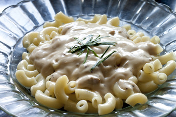 Macaroni in dish transparent on black background.